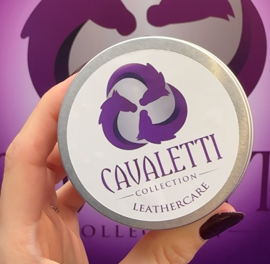 Hand holding a tin of Cavaletti Collection Leathercare against a branded purple background