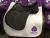 A black Cavaletti GP Saddle EX DEMO 18 Black sitting on a white quilted saddle pad with the Cavaletti Collection logo.