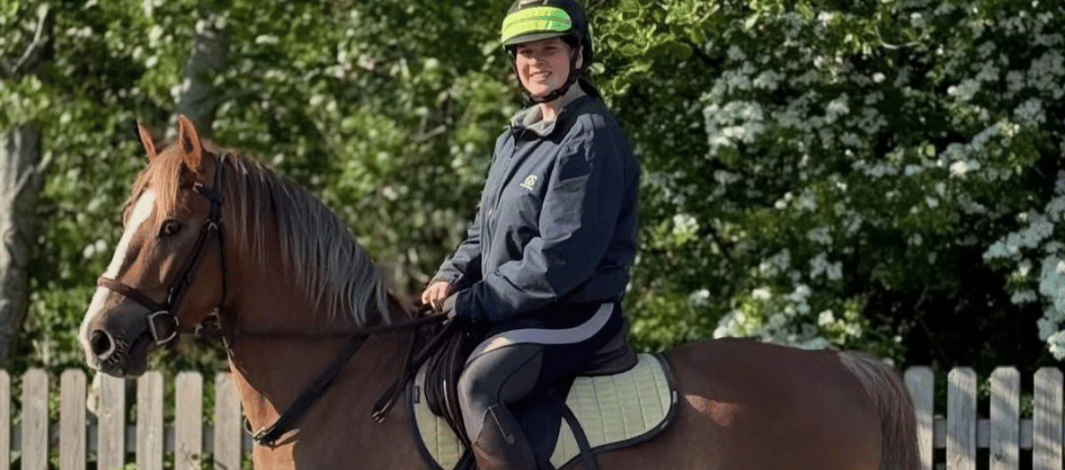 Rider sitting on a light brown horse with a bridle and light saddle pad in a quiet outdoor setting, Cavaletti Collection. Photo credit: jaffas.adventures.